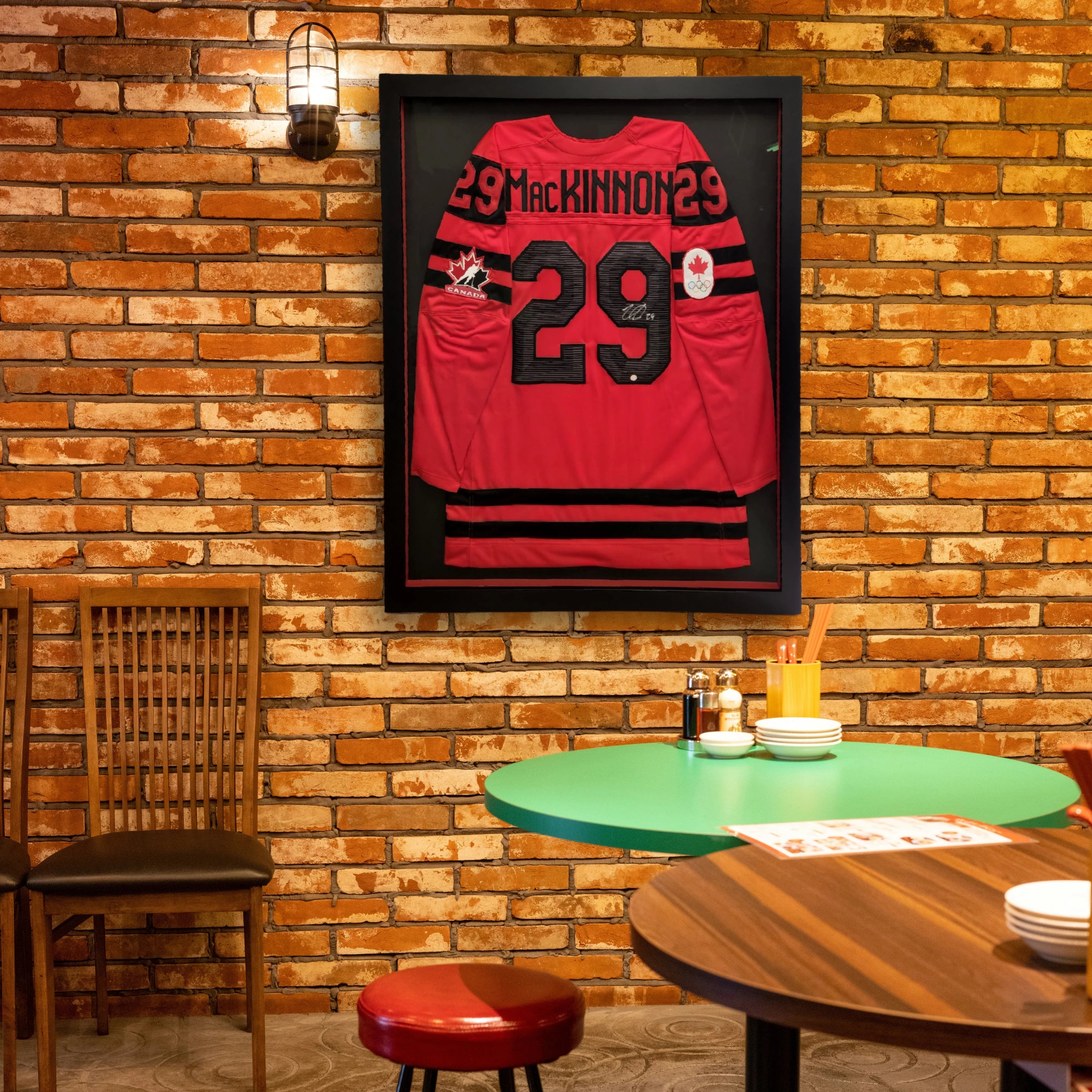 Autographed jersey displayed in a frame with red and white mat walls