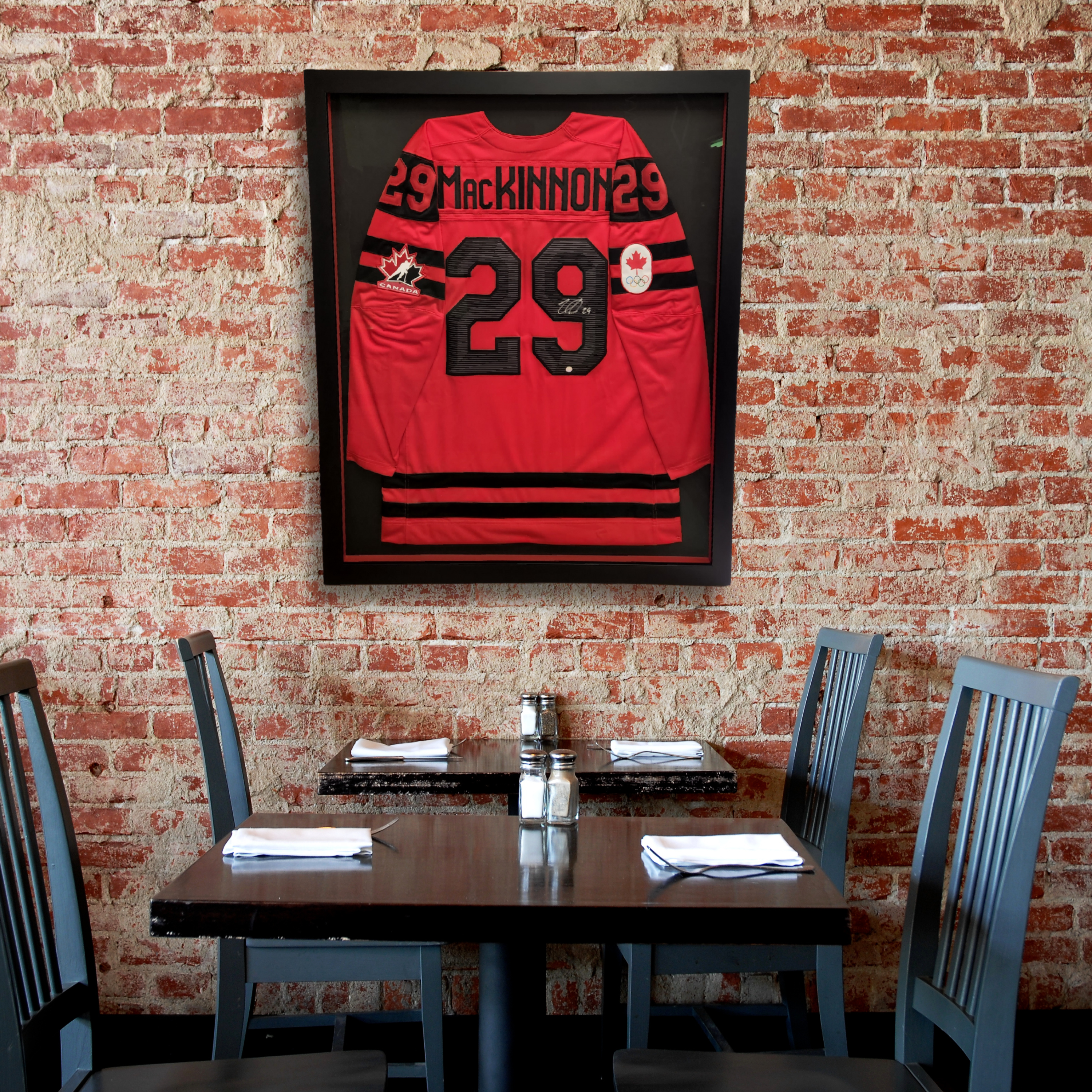 Gallery wall featuring multiple framed hockey jerseys in assorted styles